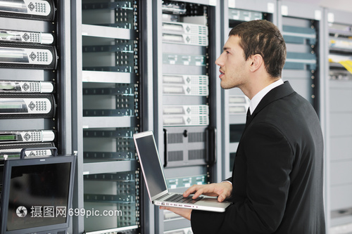 轻的IT工程师商务人员与薄的现代铝笔记本电脑 网络服务器机房中的高效协作